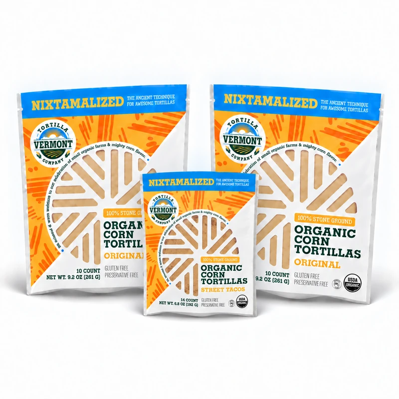 One smaller 14-count Street Taco tortilla pack centered in front of two larger 10-count Original tortilla packs from Vermont Tortilla Company, on white