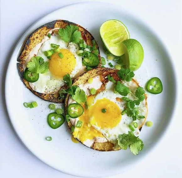 Breakfast tacos with eggs and herbs on corn tortillas