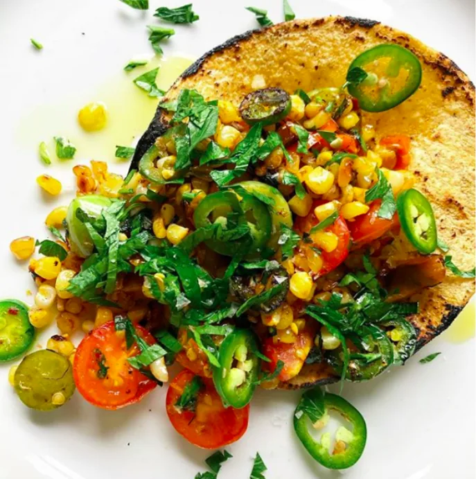 Warm corn tortilla filled with sautéed corn, cherry tomatoes, jalapeño slices and chopped cilantro