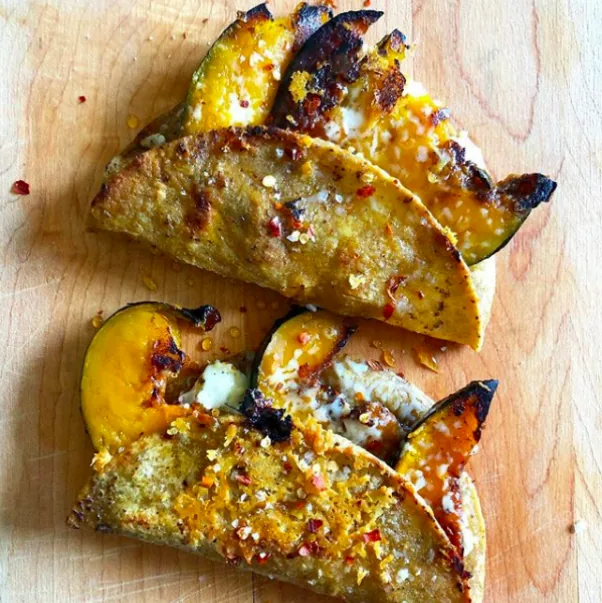 Folded corn quesadillas filled with roasted squash and cheese, with a crisp cheese crust and red pepper flakes