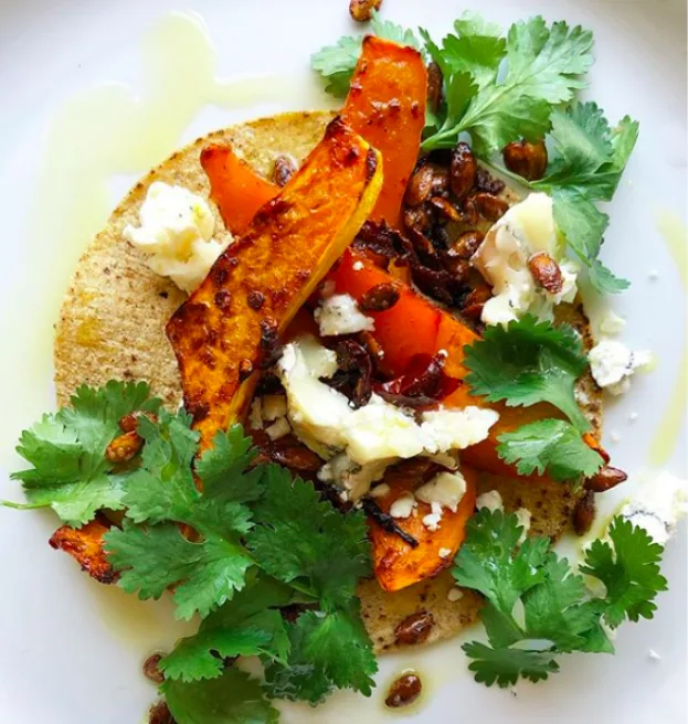 Corn tortilla with chipotle-roasted squash wedges, toasted squash seeds, goat cheese and cilantro