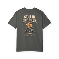 Pepper Masa Hysteria T-shirt, back with Still In One Piece lettering, a tortilla seated on an amp, and the Vermont Tortilla Company name and emblem